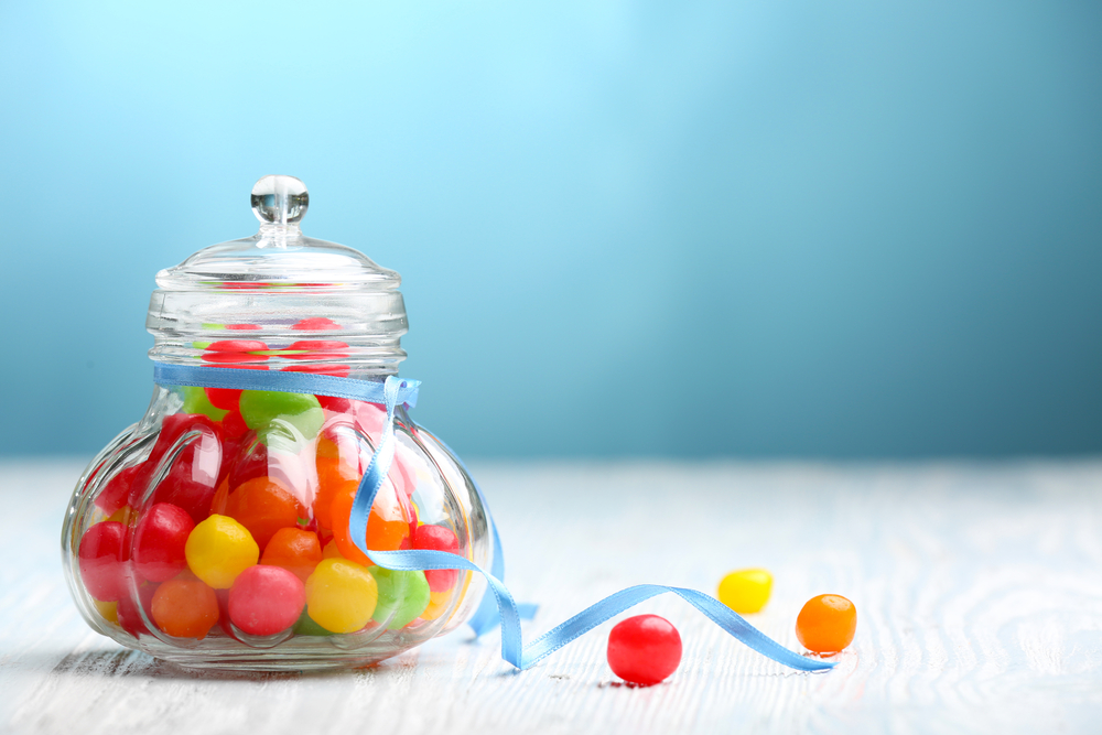 Small glass jar filled with colorful round candy pieces
