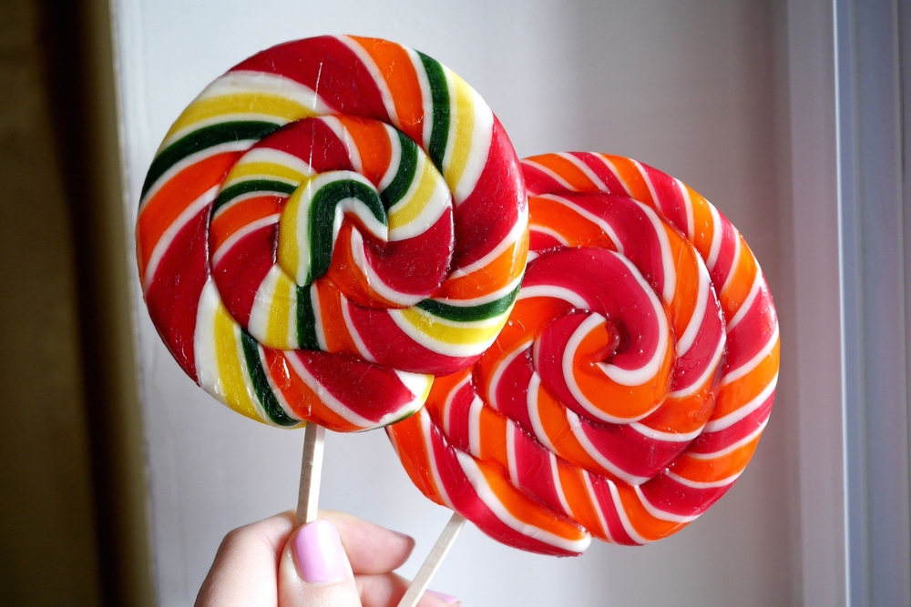 Two large swirled lollipops in red, orange, and green shades.