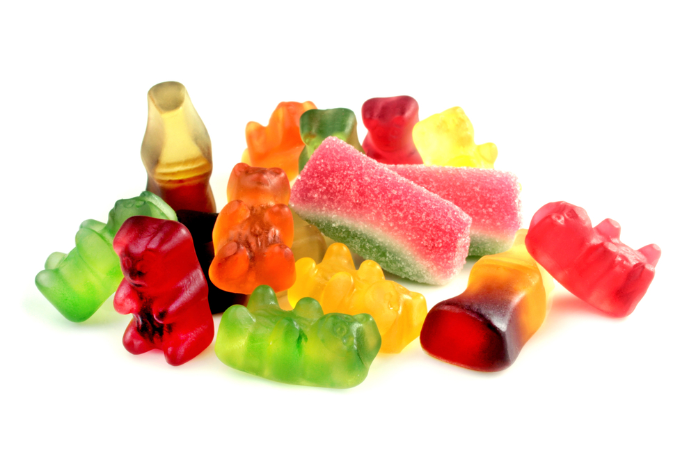 Loose colorful gummy candies, including gummy bears and watermelon slices.