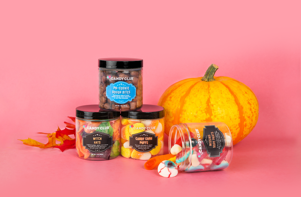 Halloween candies and a pumpkin on a pink background